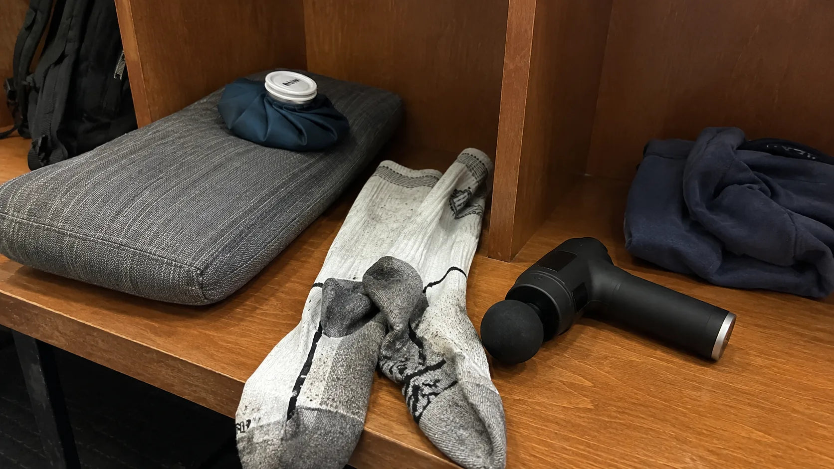 Worn compression socks, massage gun, ice pack, legs-up pillow