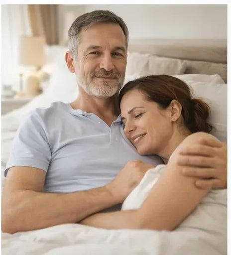 A couple lying together in bed, relaxed and close