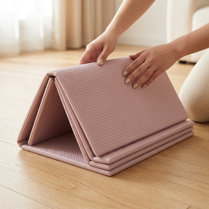 Hands folding the Vela X FlowFold yoga mat panel by panel — accordion design folds flat in seconds